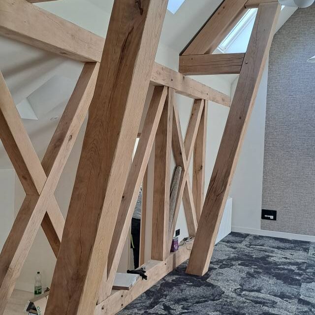 Charpente apparente en bois massif réalisée en intérieur – menuiserie traditionnelle en Normandie