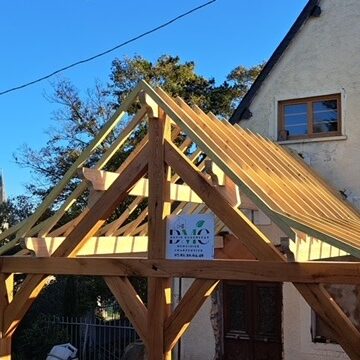 Auvent en charpente traditionnelle bois massif réalisé par DMC – pose sur maison en Normandie